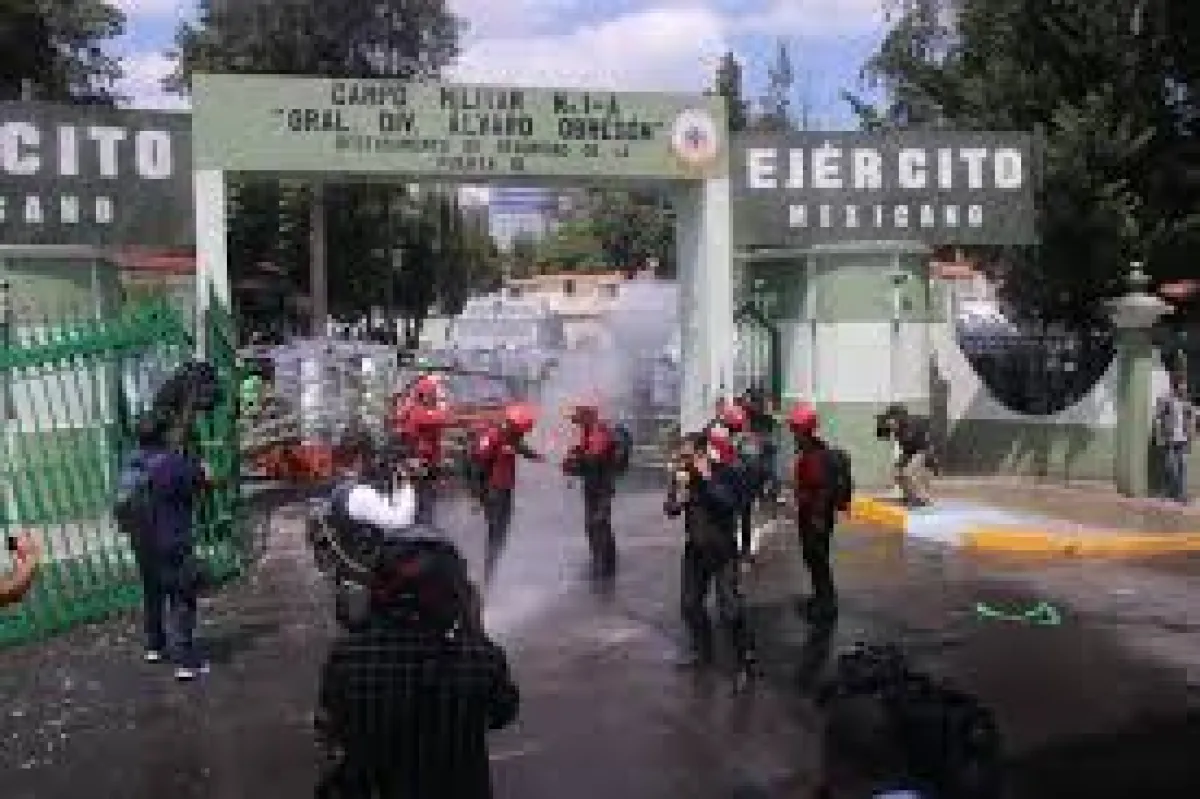 Normalistas de Ayotzinapa derriban puerta del Campo Militar 1 en protesta por los 43 desaparecidos.